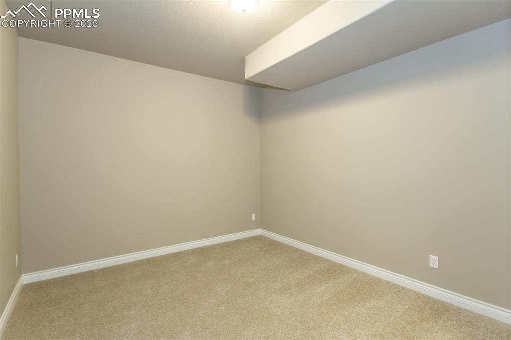 Image 28 of 28: Empty room with baseboards and light colored carpet