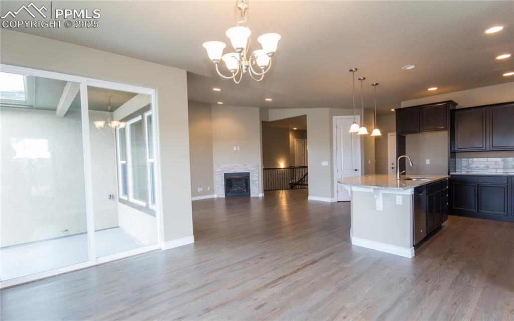 Image 9 of 28: Kitchen featuring wood finished floors, a sink, decorative backsplash, open