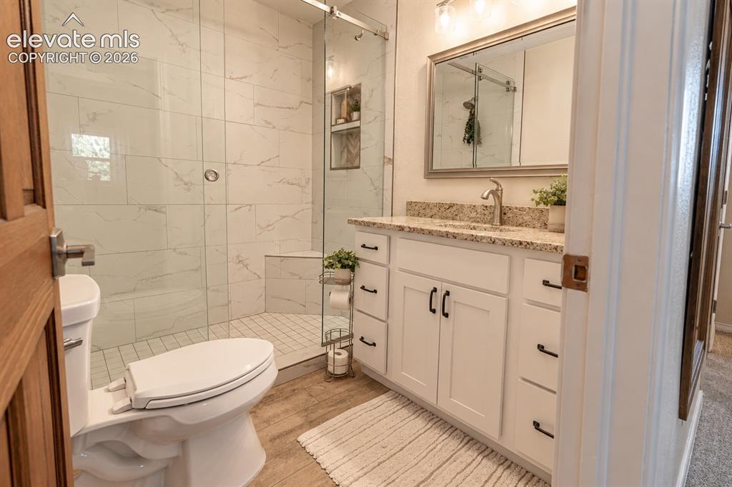 Image 14 of 30: White vanity with granite countertop, undermount sink, and brushed nickel f