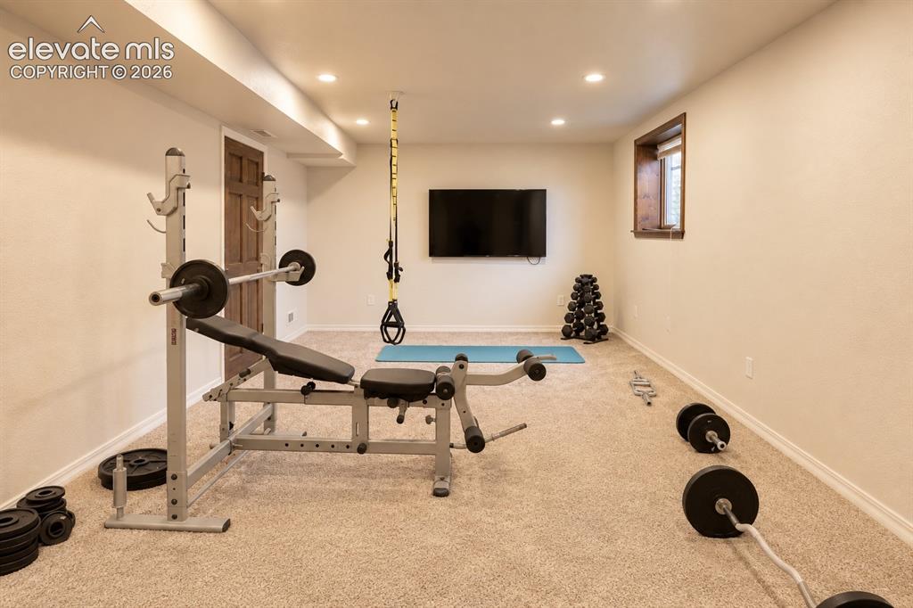 Image 18 of 30: Recessed lighting, wood-finish window trim, and neutral carpet