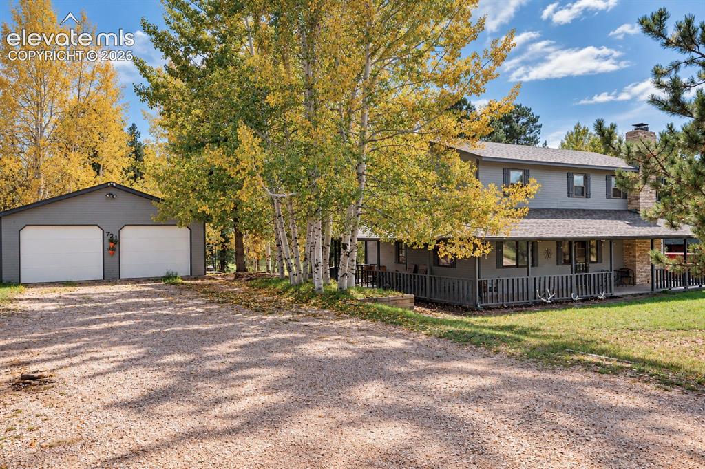 Image 30 of 30: Two-story residence with a covered porch and stone chimney