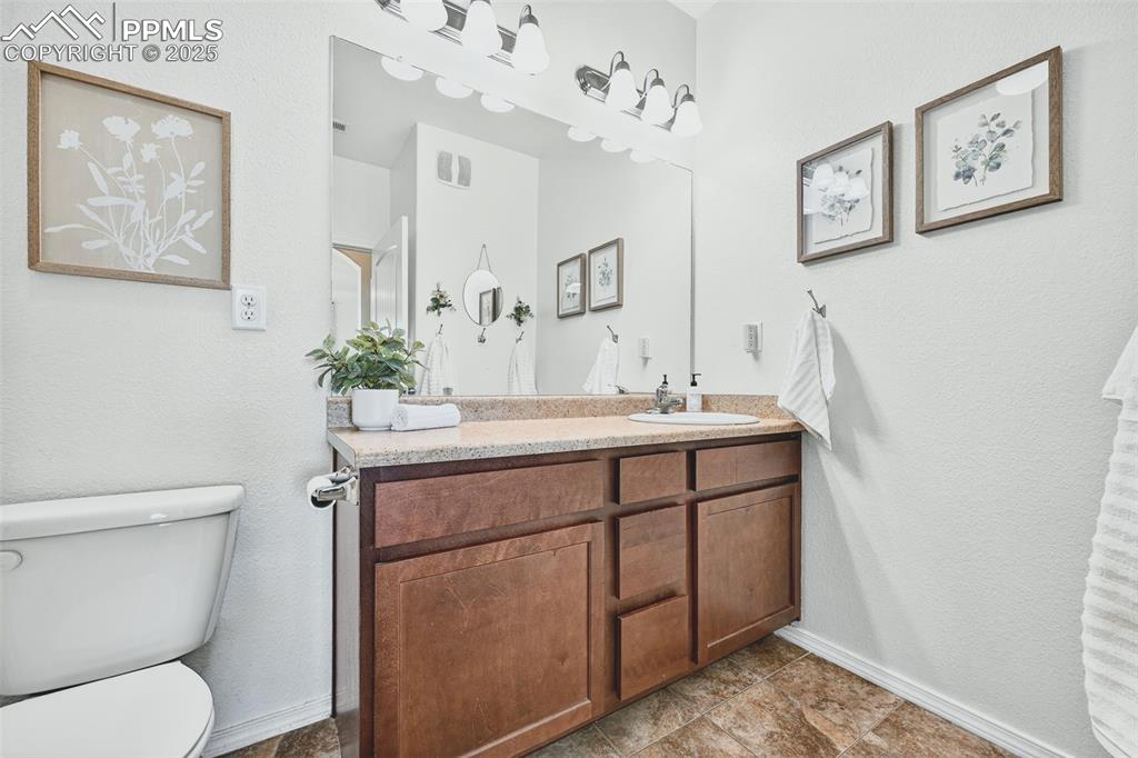 Image 14 of 25: Bathroom featuring a textured wall and vanity