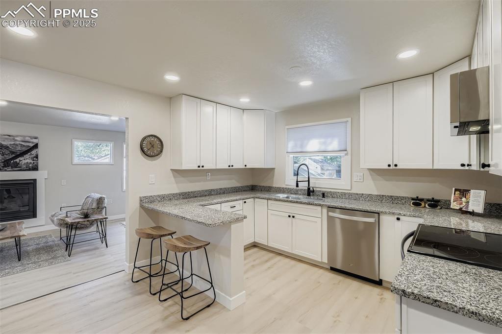 Image 8 of 31: Eat in kitchen w/granite counters, new cabinets and Stainless Steel applian