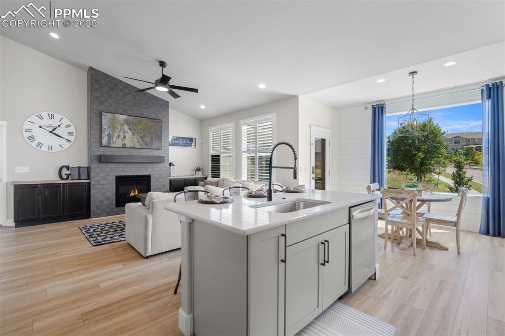 Image 14 of 37: Kitchen with lofted ceiling, light stone countertops, light wood-type floor