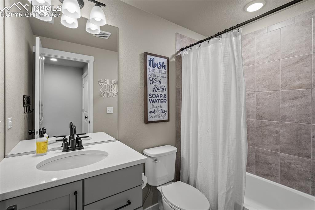Image 35 of 37: Full bath featuring vanity, shower / bath combo with shower curtain, a text