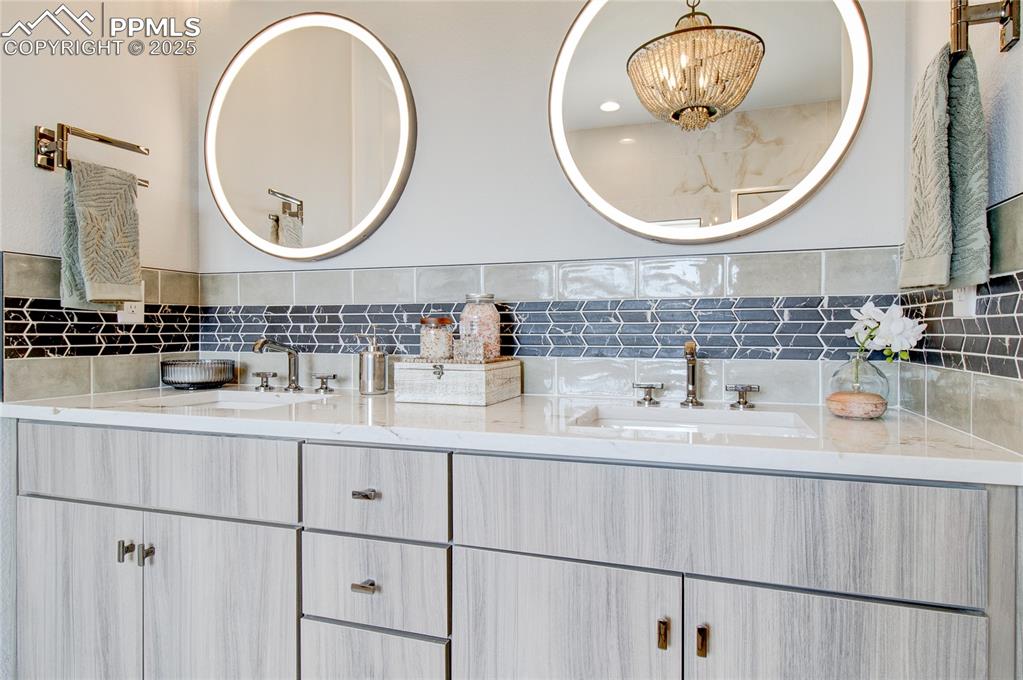 Image 14 of 29: Full bath with double vanity and backsplash