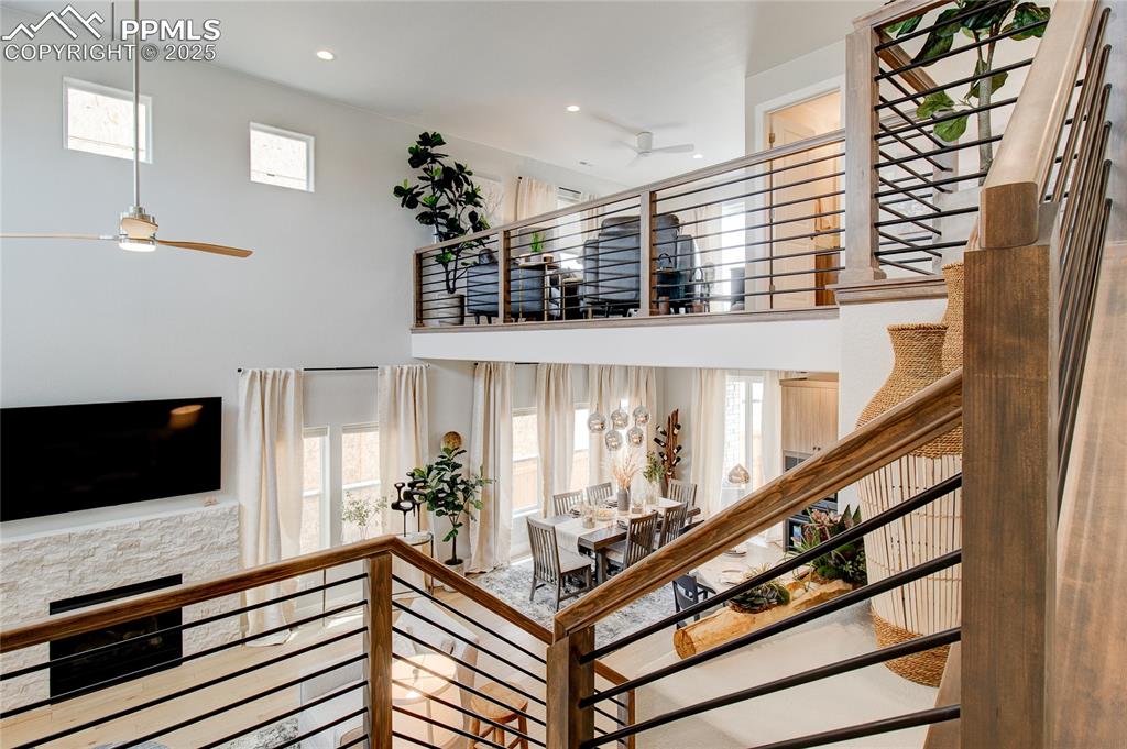 Image 16 of 29: Stairway with ceiling fan, recessed lighting, and a high ceiling