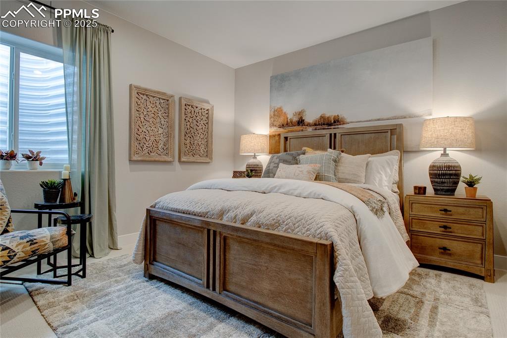 Image 25 of 29: Bedroom with light colored carpet and baseboards