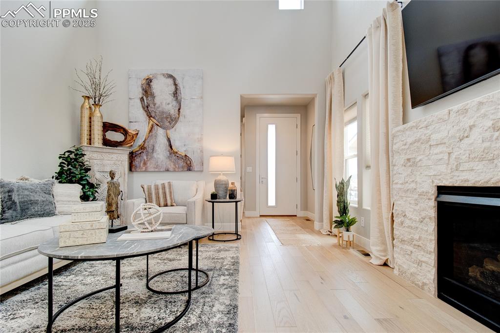 Image 6 of 29: Living room with a fireplace, hardwood / wood-style floors, and a towering