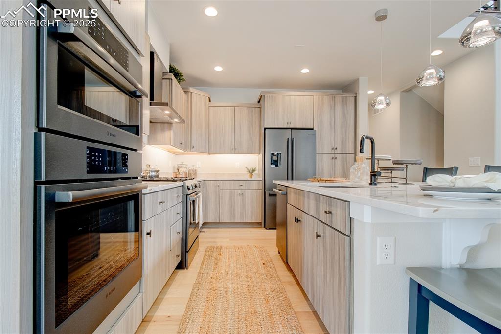 Image 9 of 29: Kitchen featuring light brown cabinetry, appliances with stainless steel fi