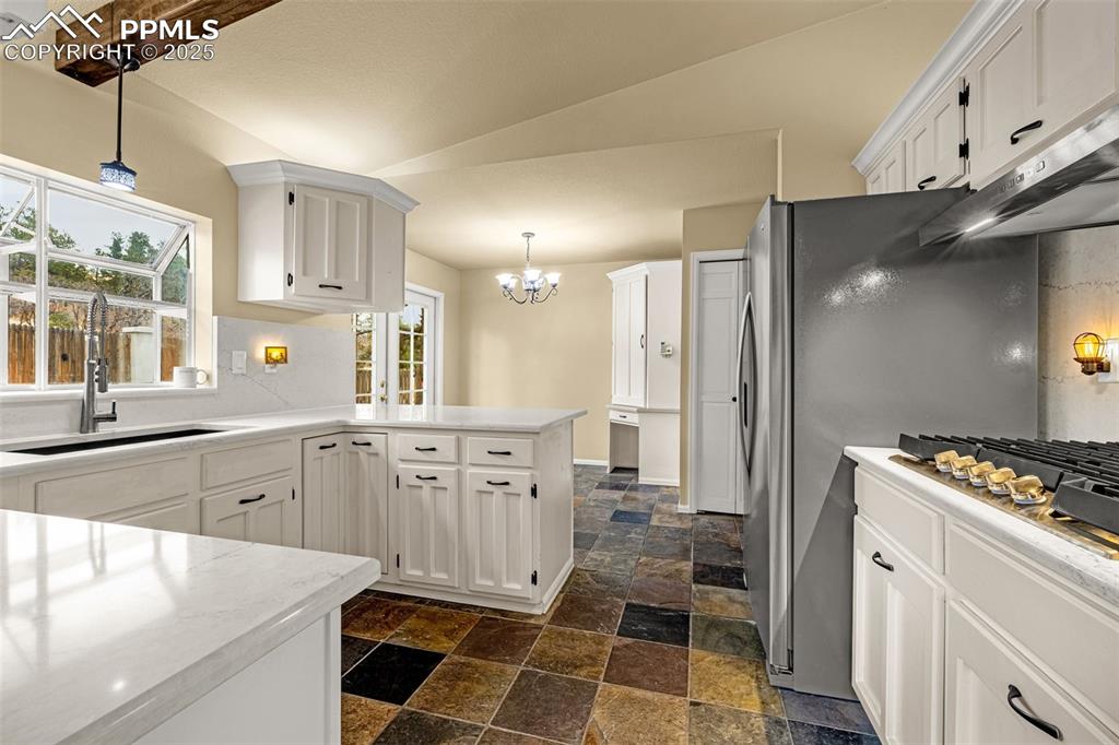 Image 10 of 50: Tiled floor with Quartz counter tops, french doors with corner pantry