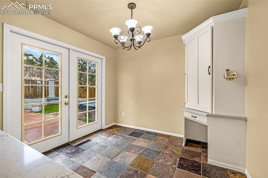 Image 12 of 50: Kitchen with french doors, and a chandelier