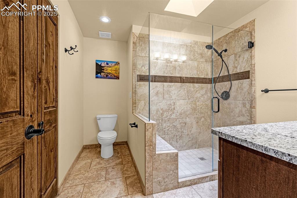 Image 21 of 50: Full bathroom with a shower stall, recessed lighting, vanity, and a skyligh