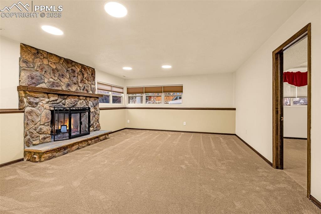 Image 24 of 50: Lower level family room with fireplace