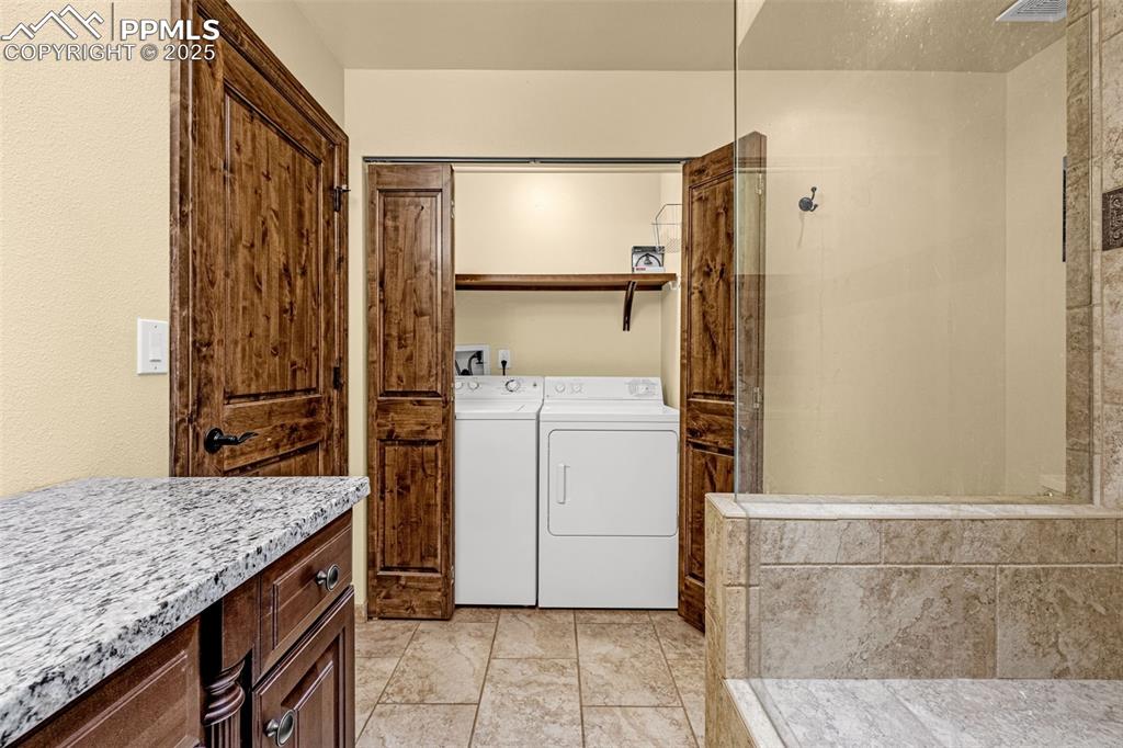 Image 27 of 50: Bathroom featuring washing machine and dryer