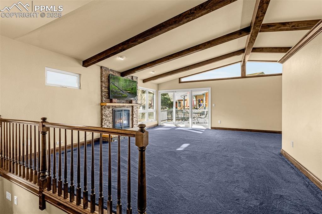 Image 8 of 50: Upper level living room with gas fireplace