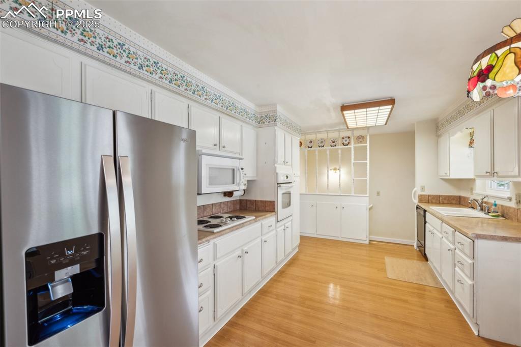 Image 11 of 30: Kitchen featuring appliances with stainless steel finishes, light counterto