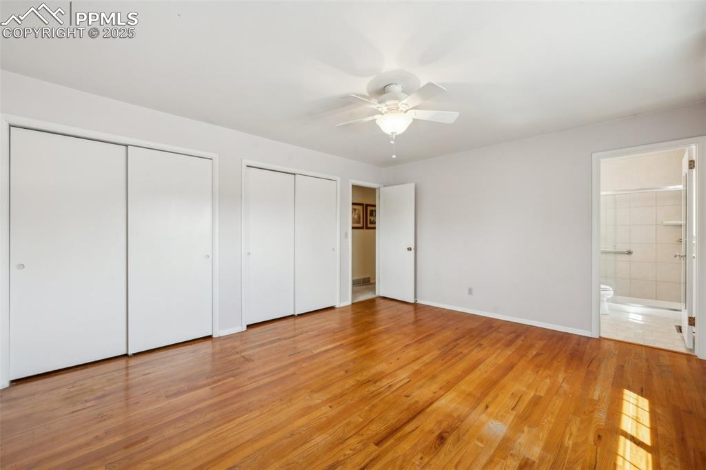 Image 18 of 30: Unfurnished bedroom with two closets, light wood-type flooring, ensuite bat