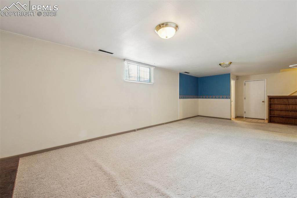 Image 26 of 30: Below grade area featuring stairs and light carpet