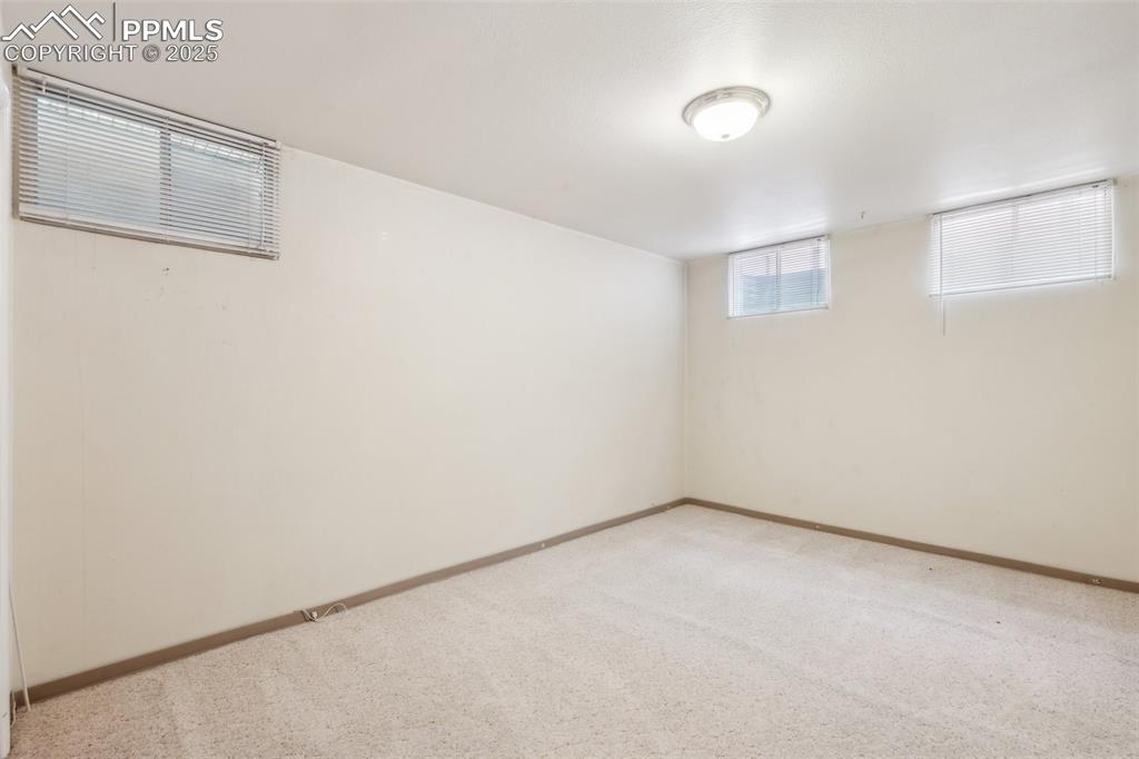 Image 27 of 30: Basement featuring light colored carpet and baseboards