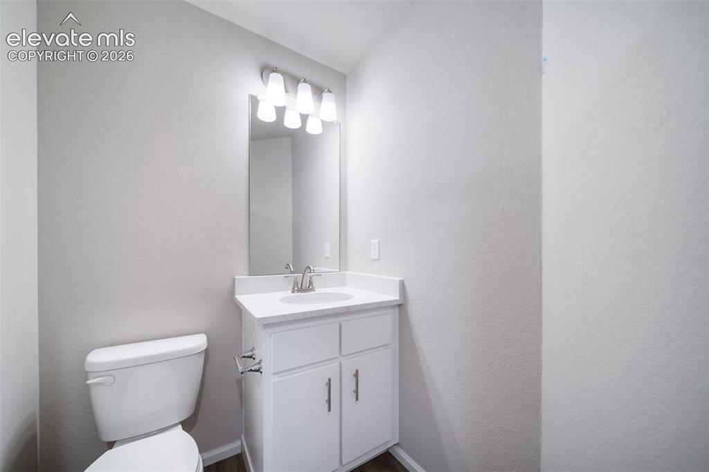 Image 11 of 18: Bathroom vanity with a white countertop and integrated sink, chrome faucet,