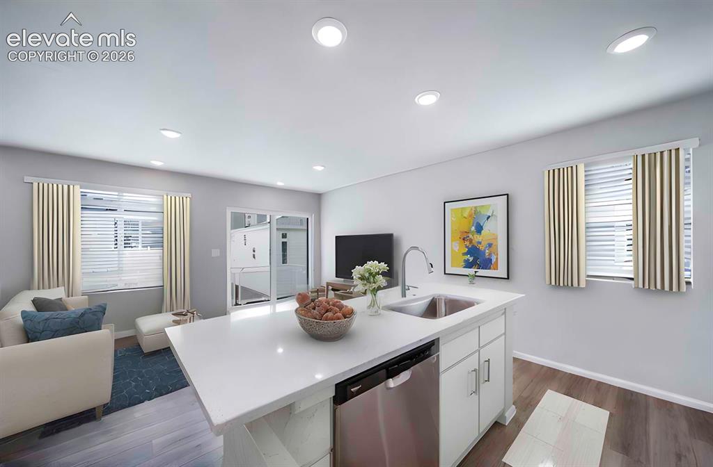 Image 15 of 18: Open-concept living area with a kitchen island featuring a stainless steel 