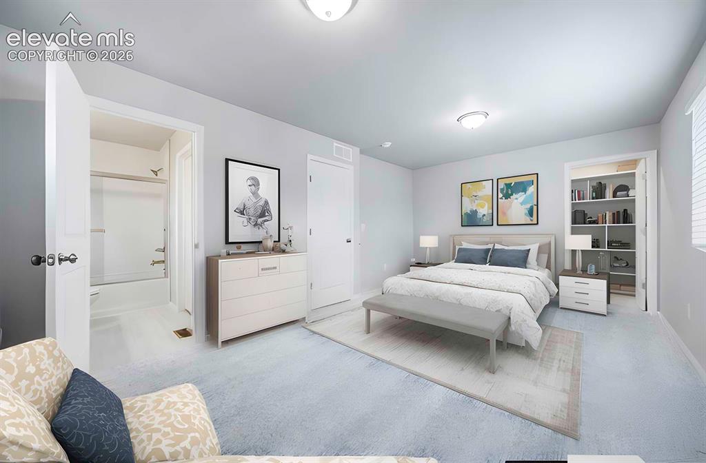 Image 16 of 18: Light-toned walls complement the gray carpeting in this bedroom, featuring 