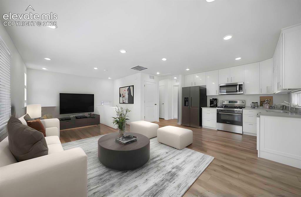 Image 3 of 18: Open-concept living area featuring wood-finish flooring and recessed lighti