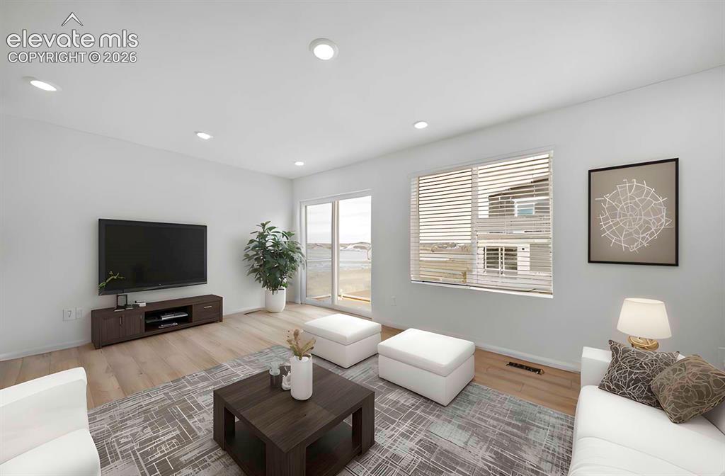 Image 4 of 18: Open living area featuring wood-finish flooring, recessed lighting, and whi