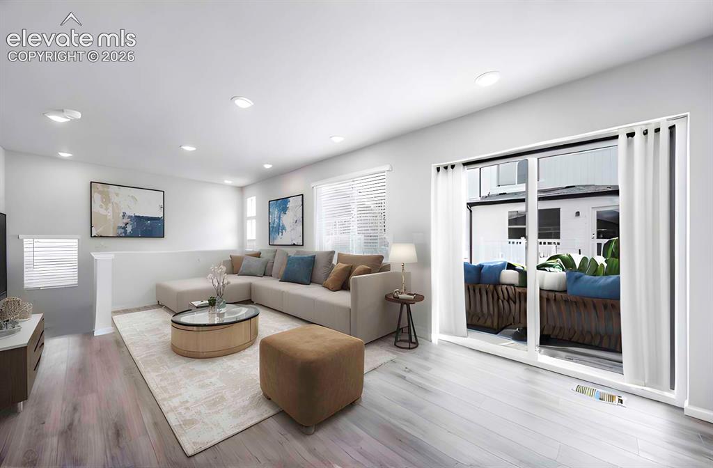 Image 9 of 18: Living area featuring wood-finish flooring, recessed lighting, and a slidin