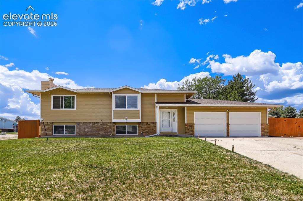 Image 1 of 19: Split-level residence featuring a two-car garage, stone facade accents, and