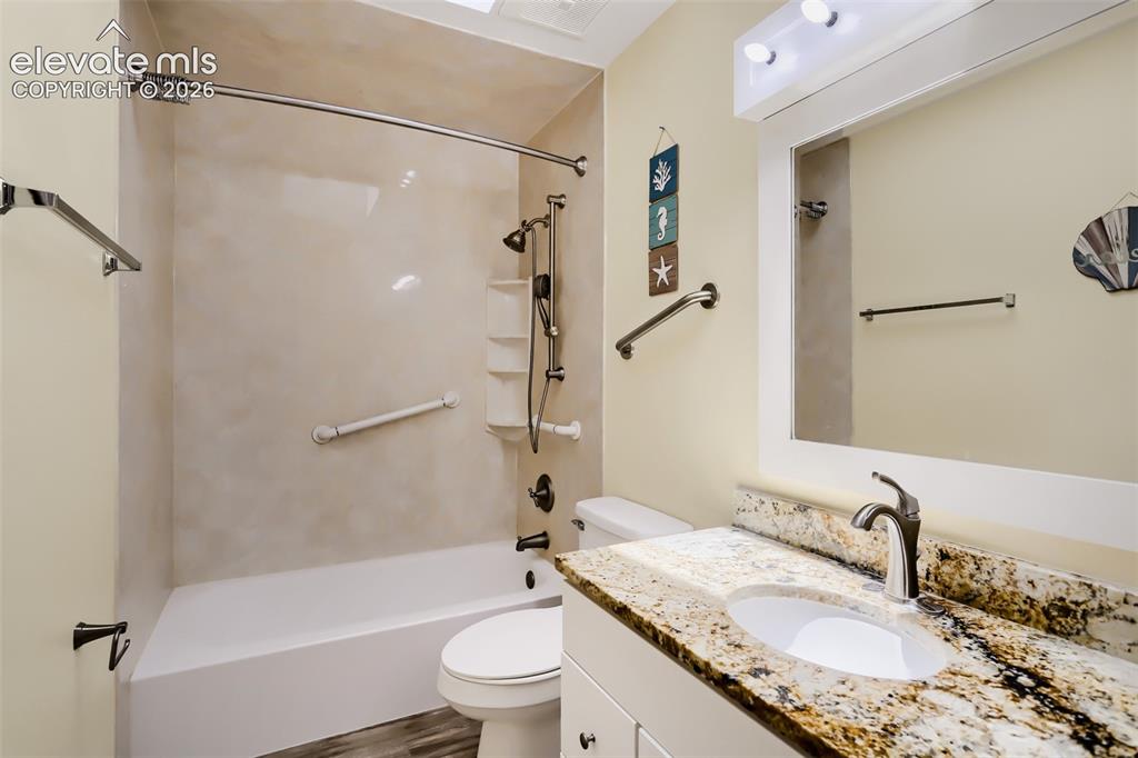 Image 11 of 19: Bathroom featuring a vanity with a stone-finish countertop, undermount sink