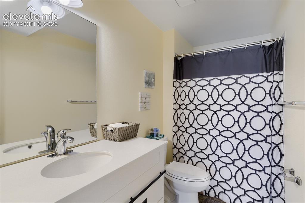 Image 13 of 19: Bathroom featuring a vanity with an integrated sink and chrome faucet, a re