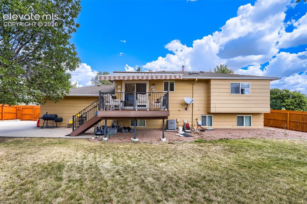 Image 16 of 19: Rear exterior featuring a multi-level deck with black railings, an extendab