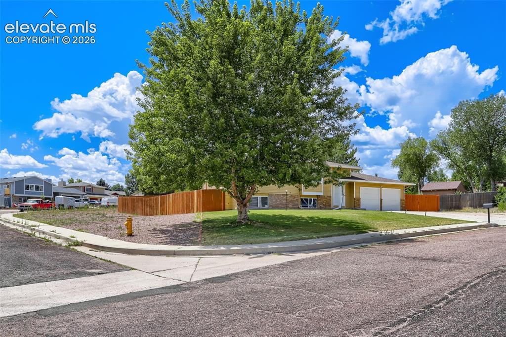 Image 17 of 19: Split-level residence featuring a two-car garage, partial brick facade, and