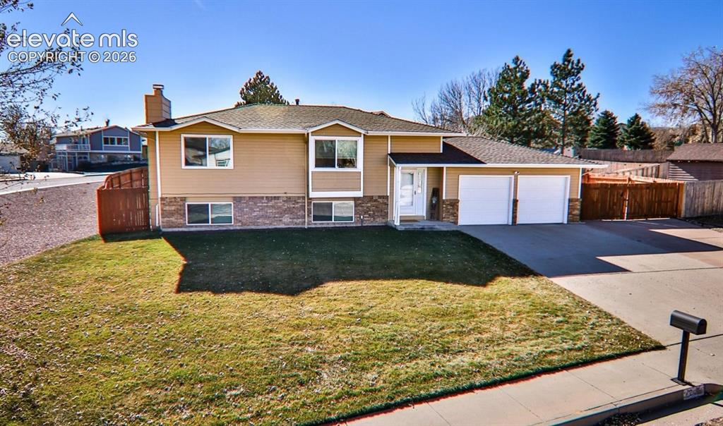 Image 18 of 19: Split-level residence featuring a two-car garage, durable asphalt shingle r