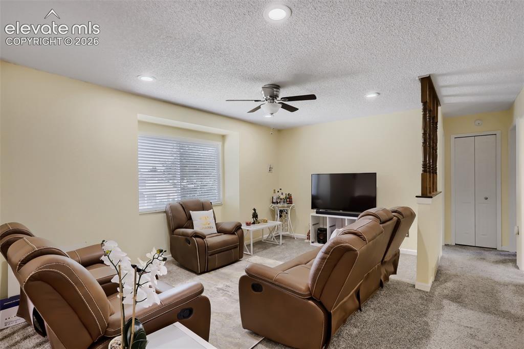 Image 3 of 19: Carpeted living area featuring a single window with blinds, recessed lighti