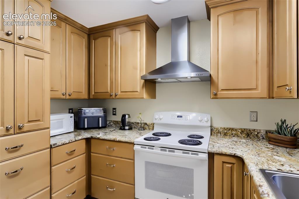 Image 6 of 19: Kitchen featuring light wood cabinetry with brushed nickel hardware, granit