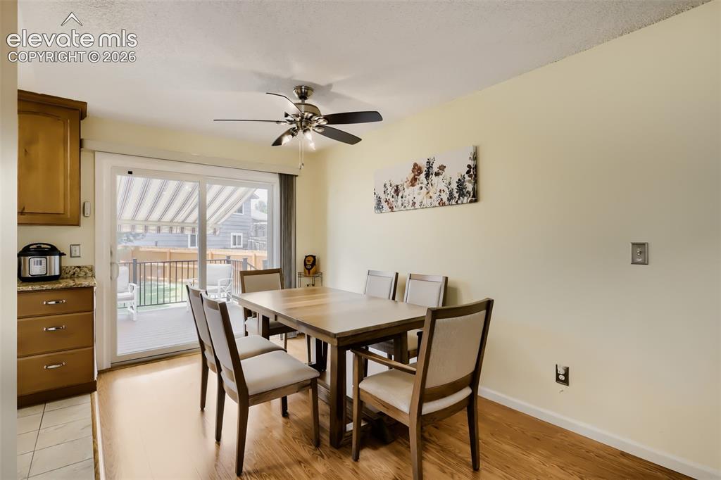 Image 7 of 19: Dining area featuring wood-finish flooring, a ceiling fan with integrated l