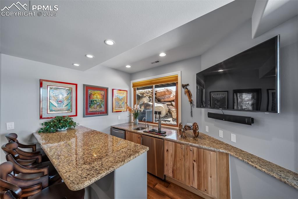 Image 29 of 50: Kitchen featuring a peninsula, dark wood-type flooring, a kitchen breakfast