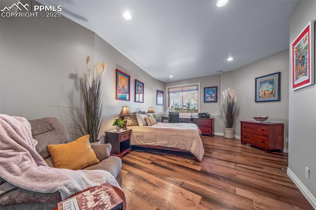 Image 31 of 50: Bedroom with wood finished floors and recessed lighting