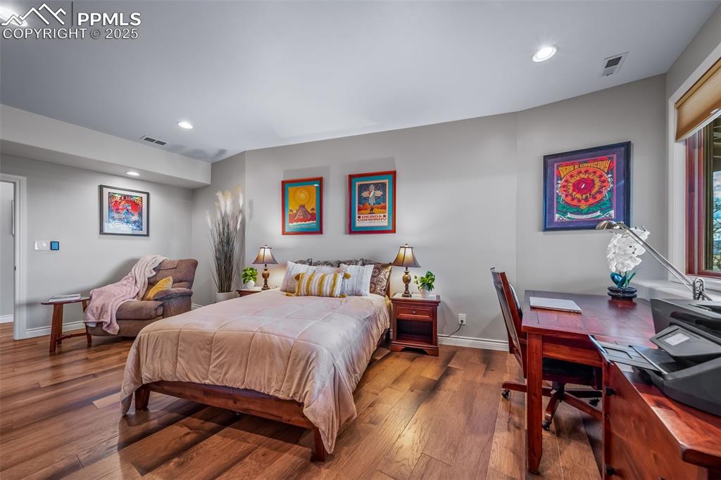 Image 32 of 50: Bedroom with wood finished floors, recessed lighting, and a desk