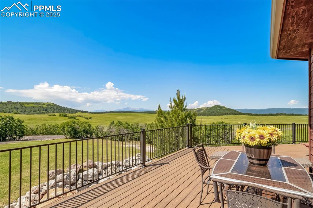 Image 41 of 50: Wooden deck with a mountain view, a view of countryside, and a lawn
