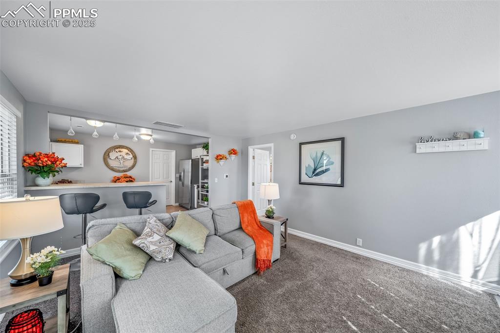 Image 44 of 50: Living room with baseboards and carpet