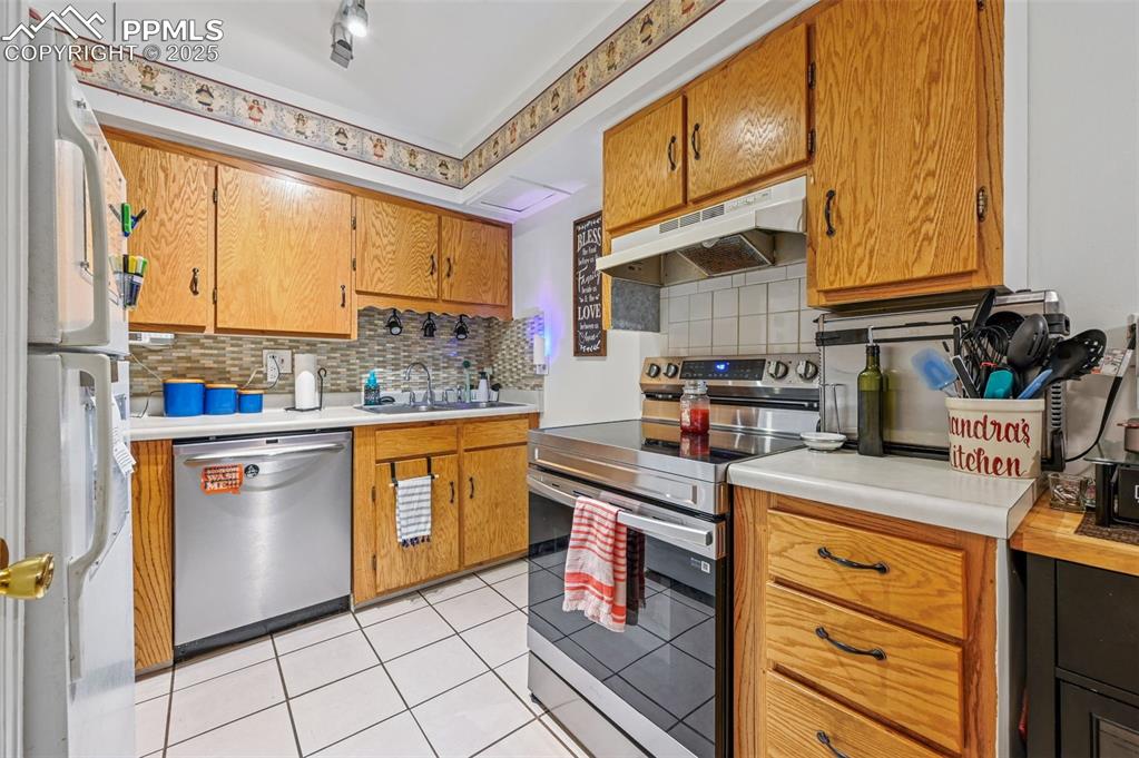 Image 11 of 21: Kitchen featuring stainless steel appliances, light countertops, and decora