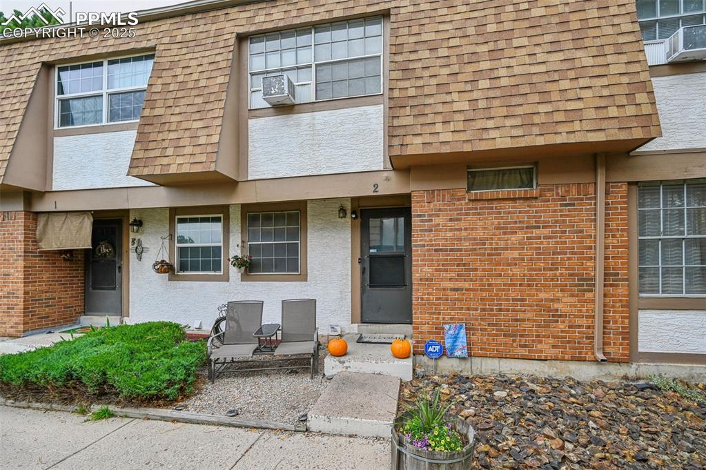 Image 2 of 21: View of front of home featuring a shingled roof, mansard roof, and stucco s