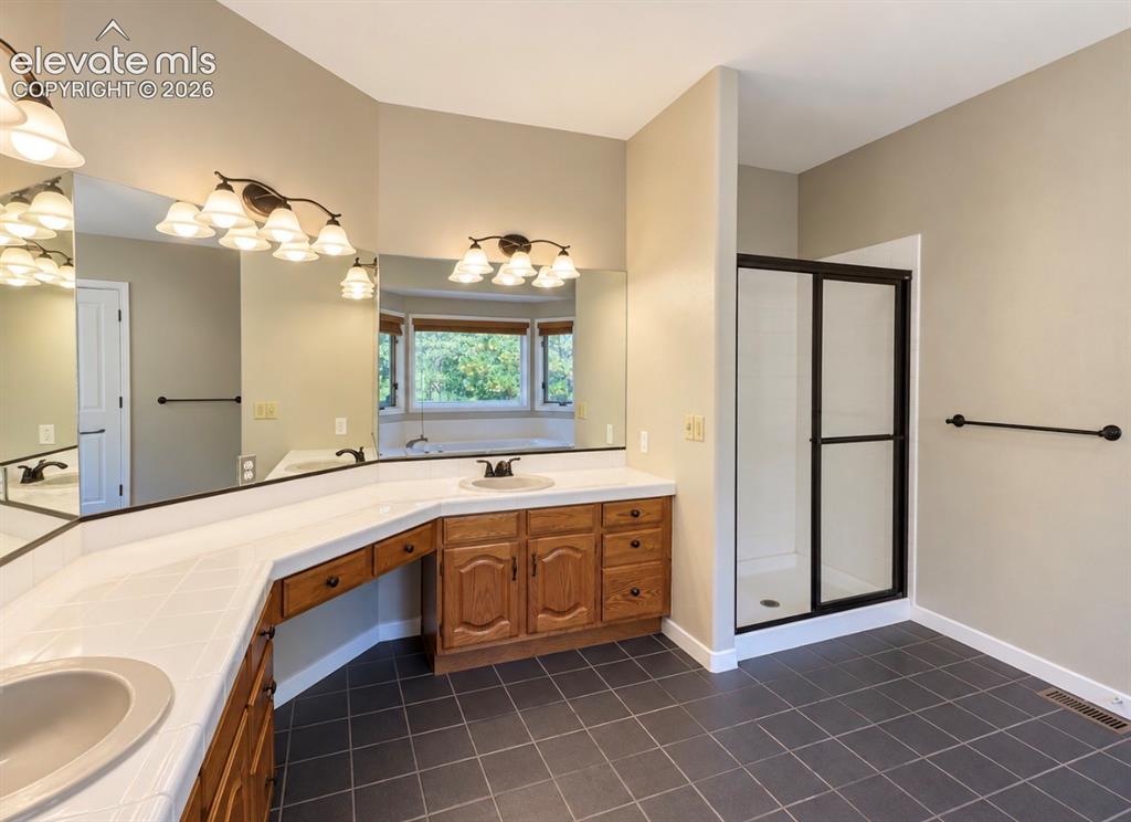 Image 6 of 8: Dual vanities, extensive counter space, built-in cabinetry, walk-in shower