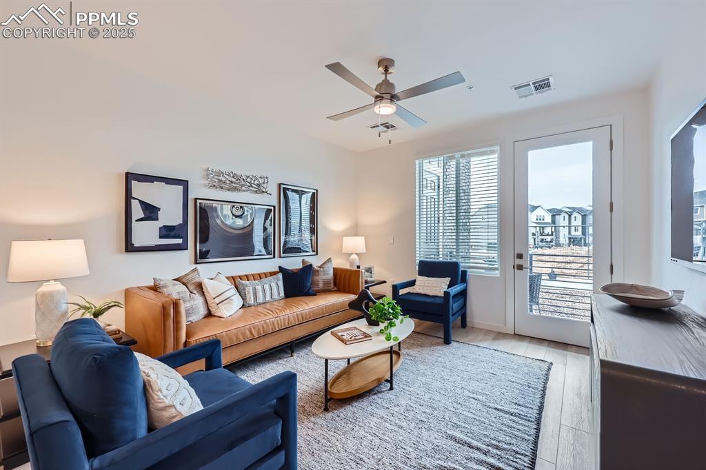 Image 2 of 9: Living area with wood finished floors and ceiling fan