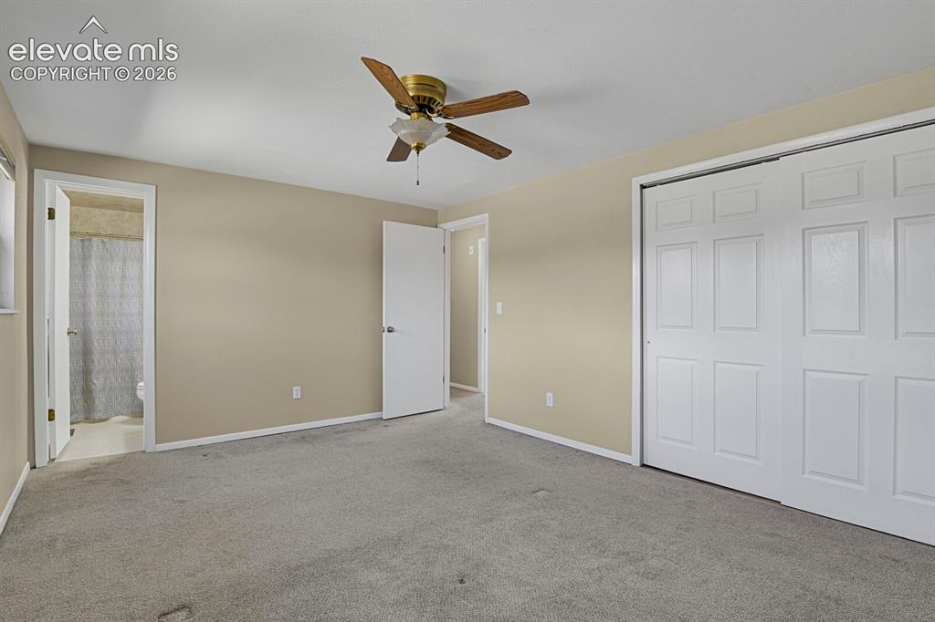 Image 15 of 34: Neutral-toned room featuring a ceiling fan with light fixture, light gray c