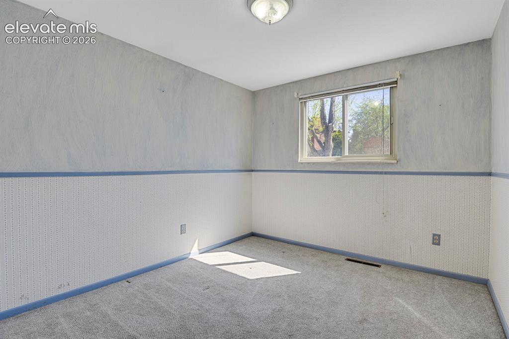 Image 18 of 34: Room with textured wall covering, a single window, and carpet flooring